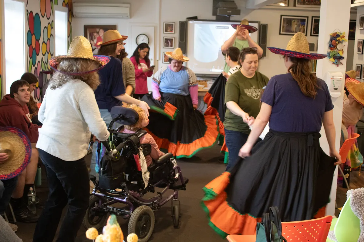Participants dancing in colorful skirts and sombreros during a cultural celebration