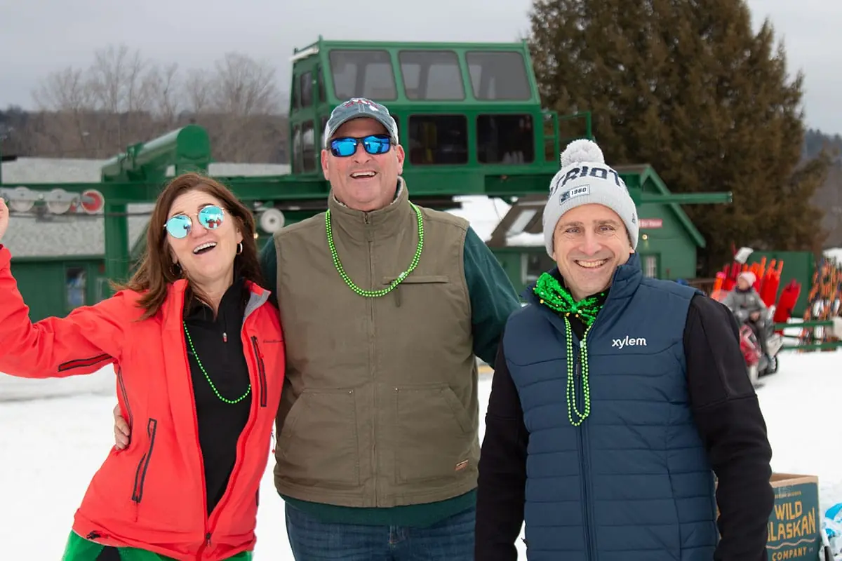 Three smiling supporters at the base of the ski hill during the Quechee Uphill Challenge