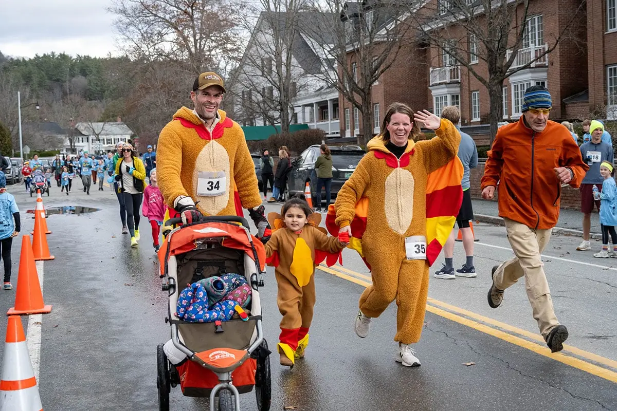 Runners in turkey costumes heading down the road during the Turkey Trot